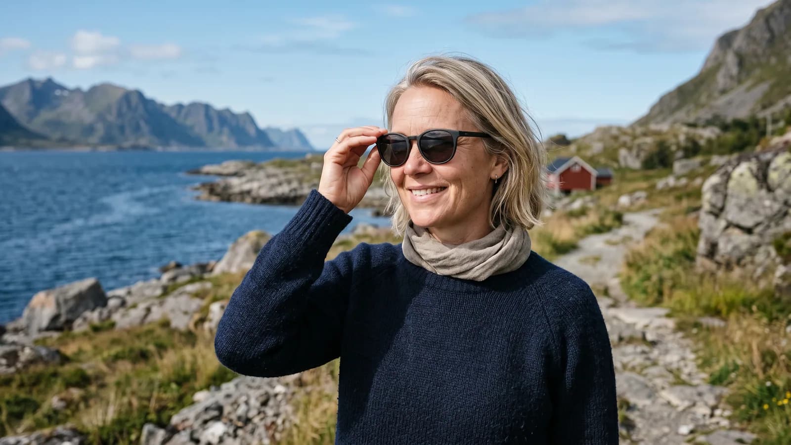 En kvinne i 40-årene tar på seg solbriller med UV-filter på en solrik dag ved kysten, vern mot UV-stråler som kan gi pingvekula.